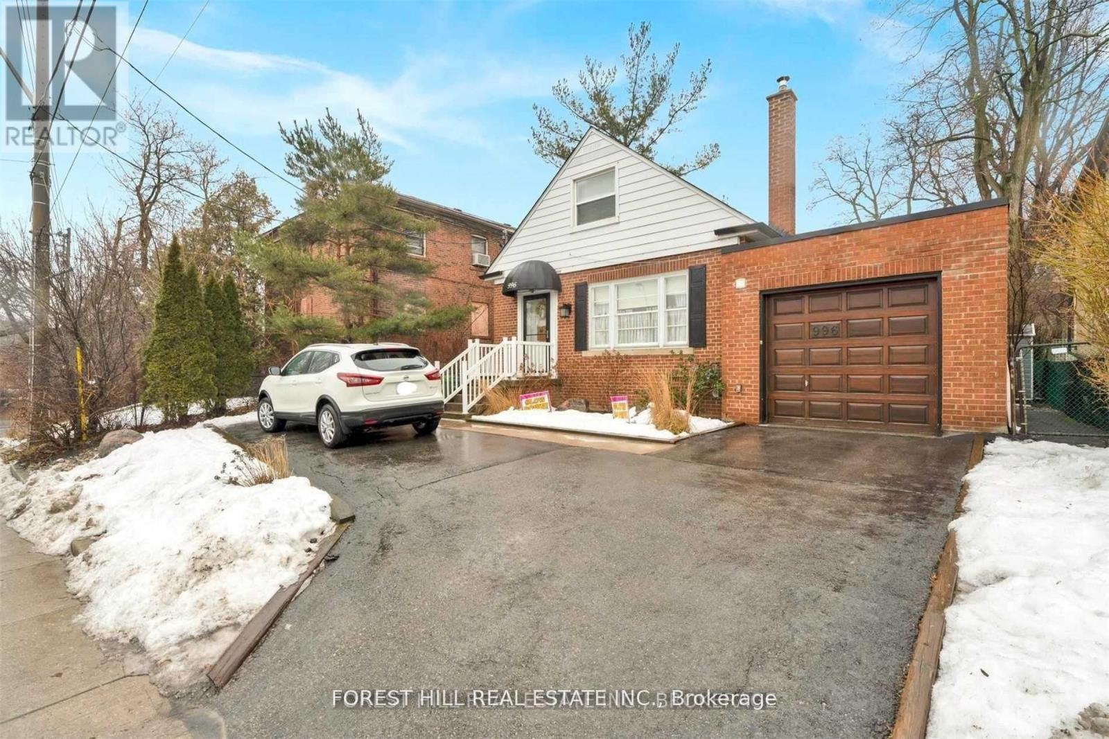 A house with a white car parked in front of it.