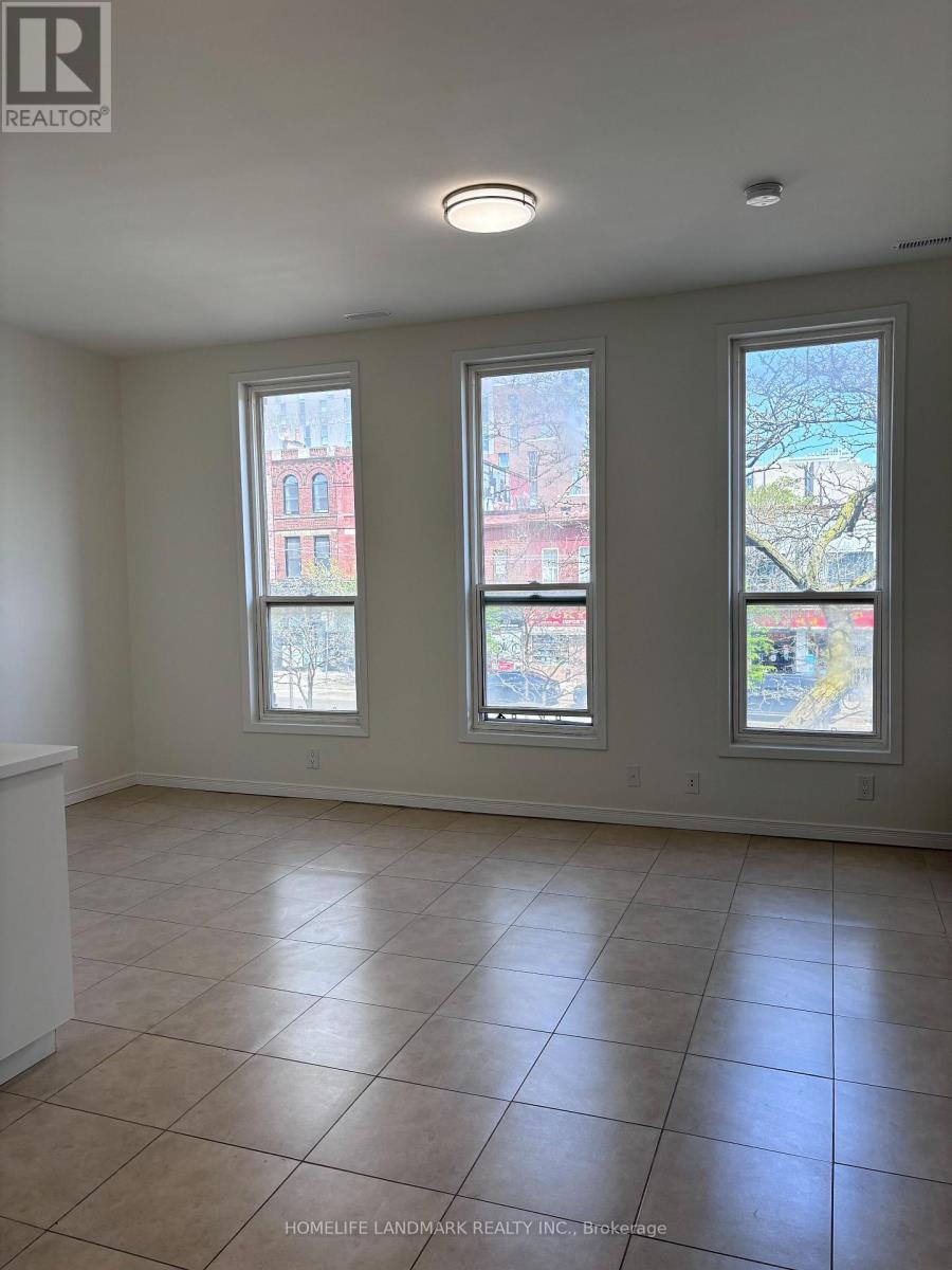 A room with tiled flooring and three windows showing an outdoor view.
