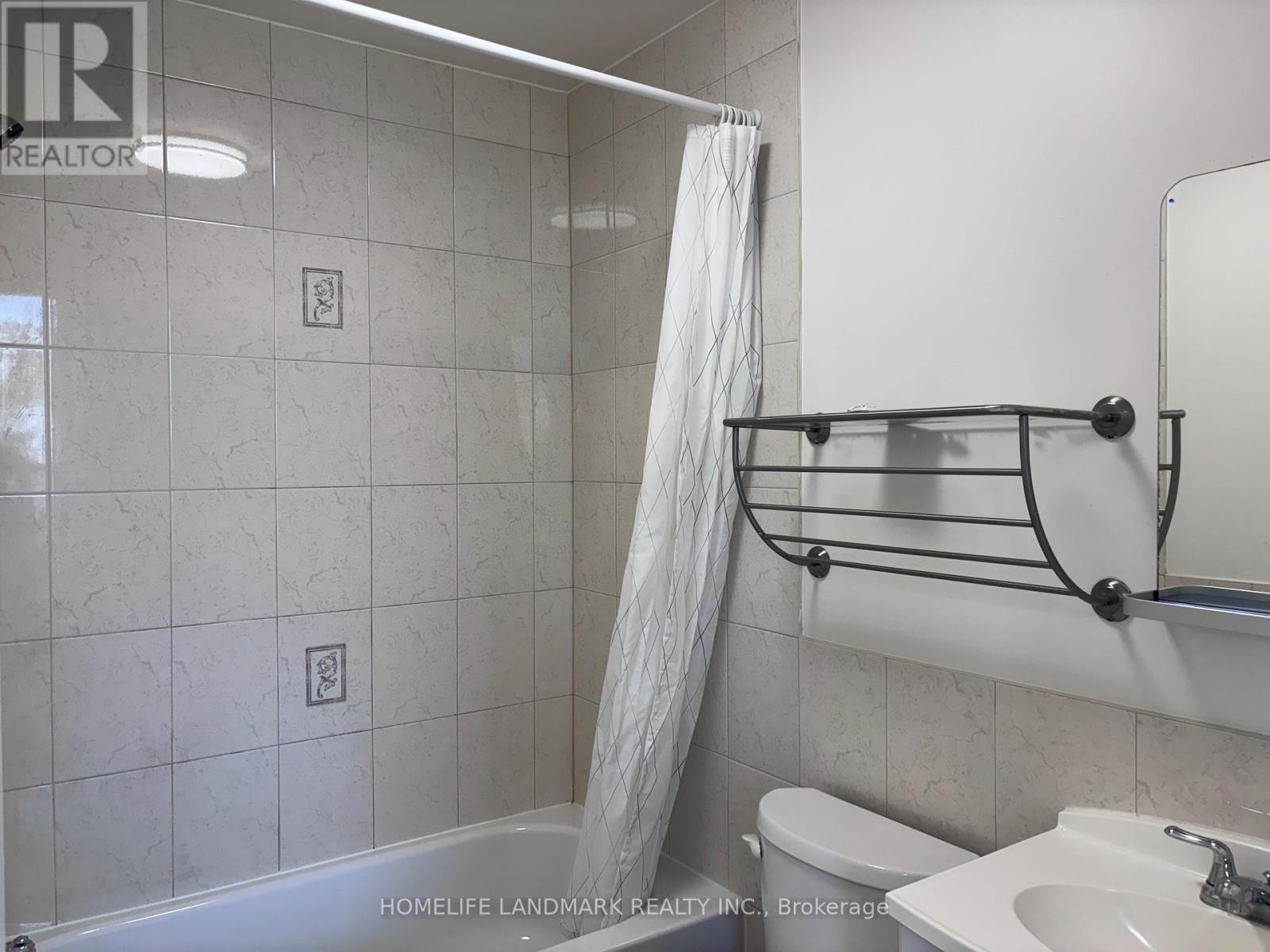 A bathroom with a white tub, toilet, and sink.