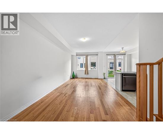 A spacious room with wooden floors and white walls.