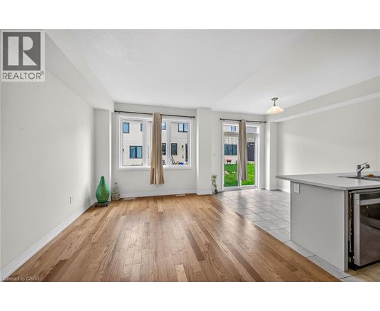 A kitchen area with a sink and a window with curtains.
