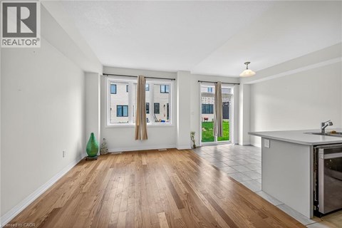A kitchen area with a sink and a window with curtains.