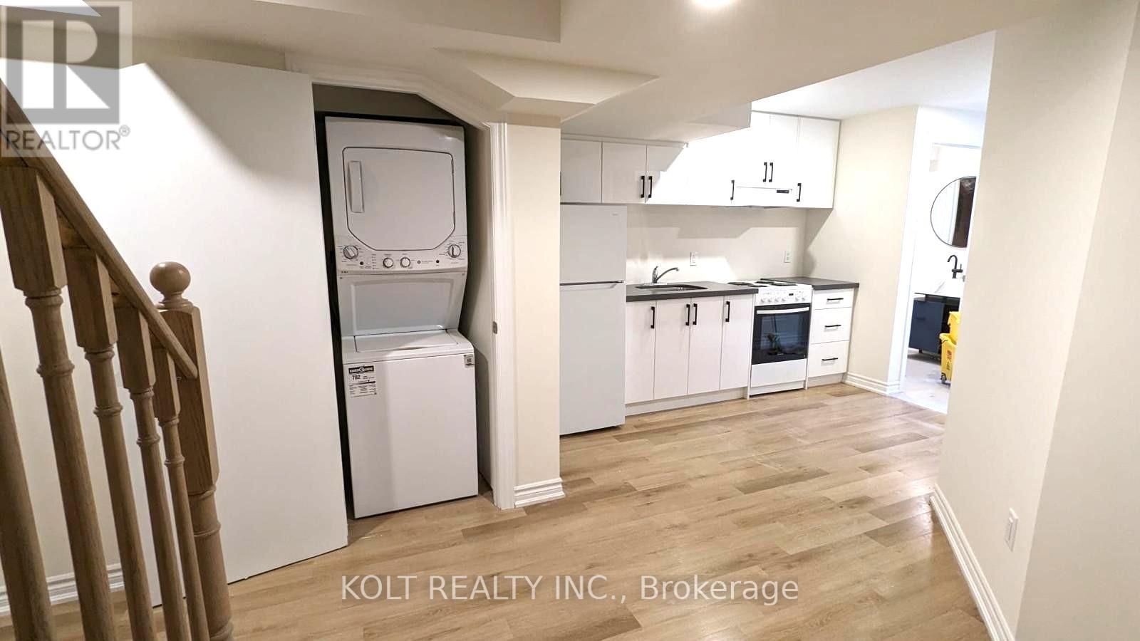 A kitchen with white cabinets and a white refrigerator.
