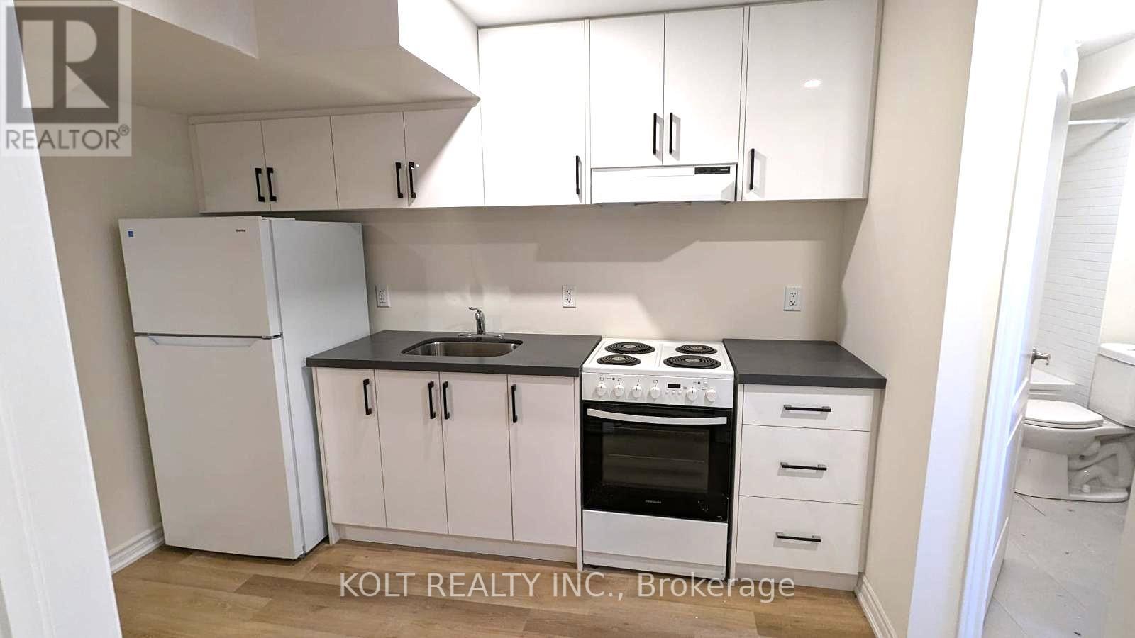 A kitchen with white cabinets and appliances.