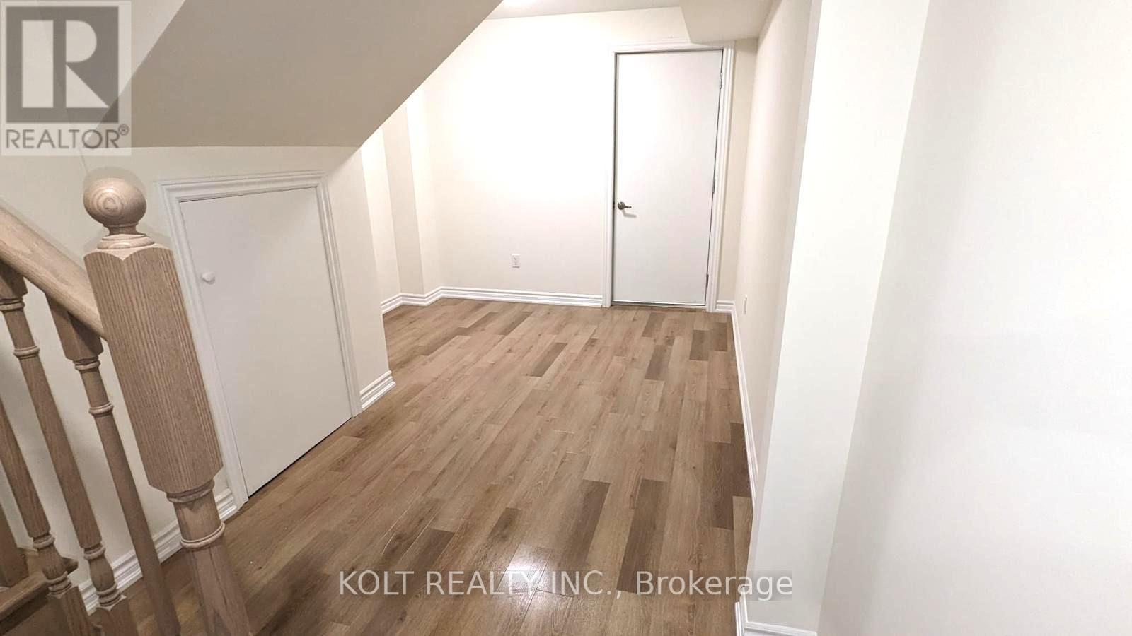 A hallway with wooden floors and white walls.