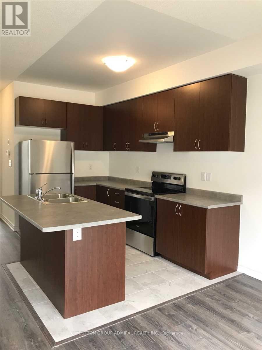 A kitchen with brown cabinets and a stainless steel refrigerator.
