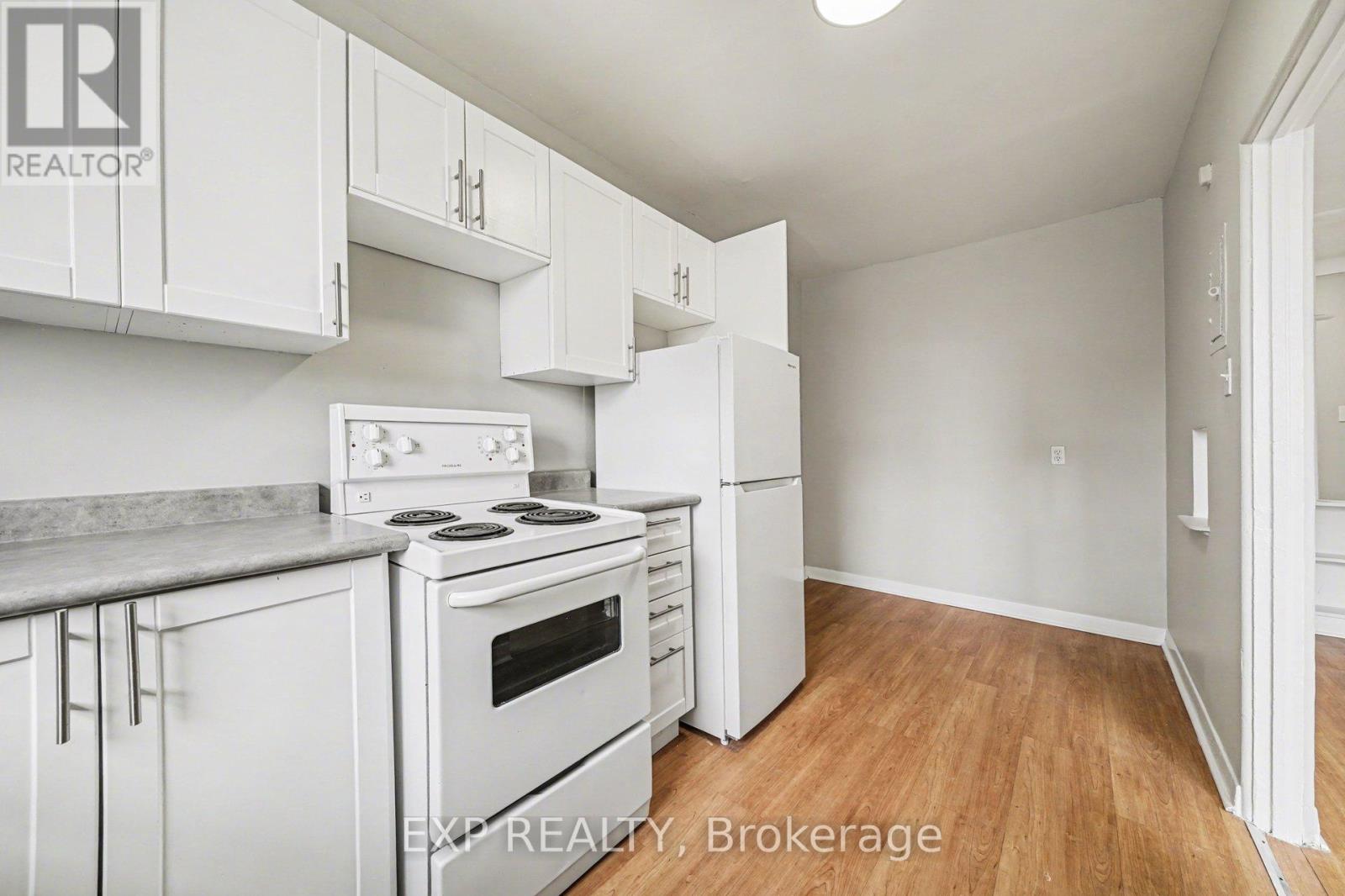 A kitchen with white cabinets and a stove top oven.
