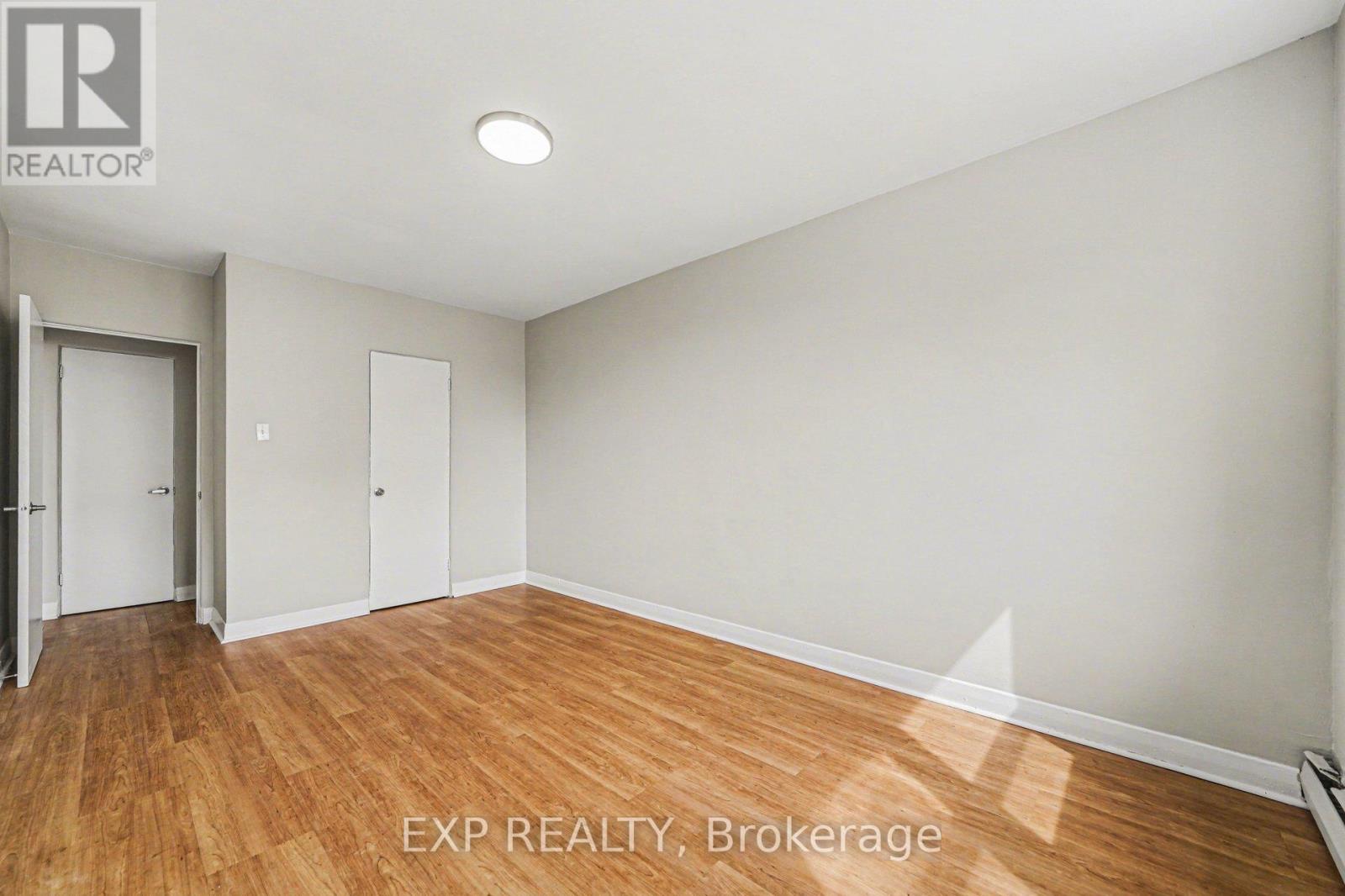 A room with wooden flooring and white walls.