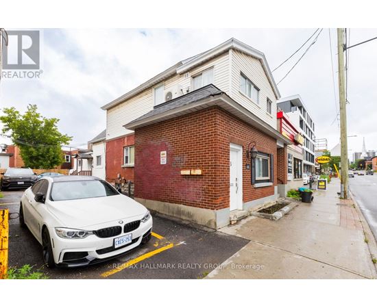 A white BMW is parked in front of a red brick building.