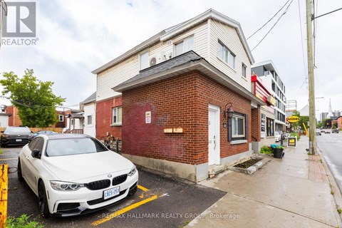 A white BMW is parked in front of a red brick building.