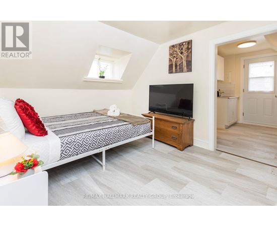 A bedroom with a bed, a dresser, and a television.