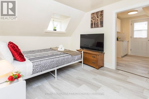 A bedroom with a bed, a dresser, and a television.