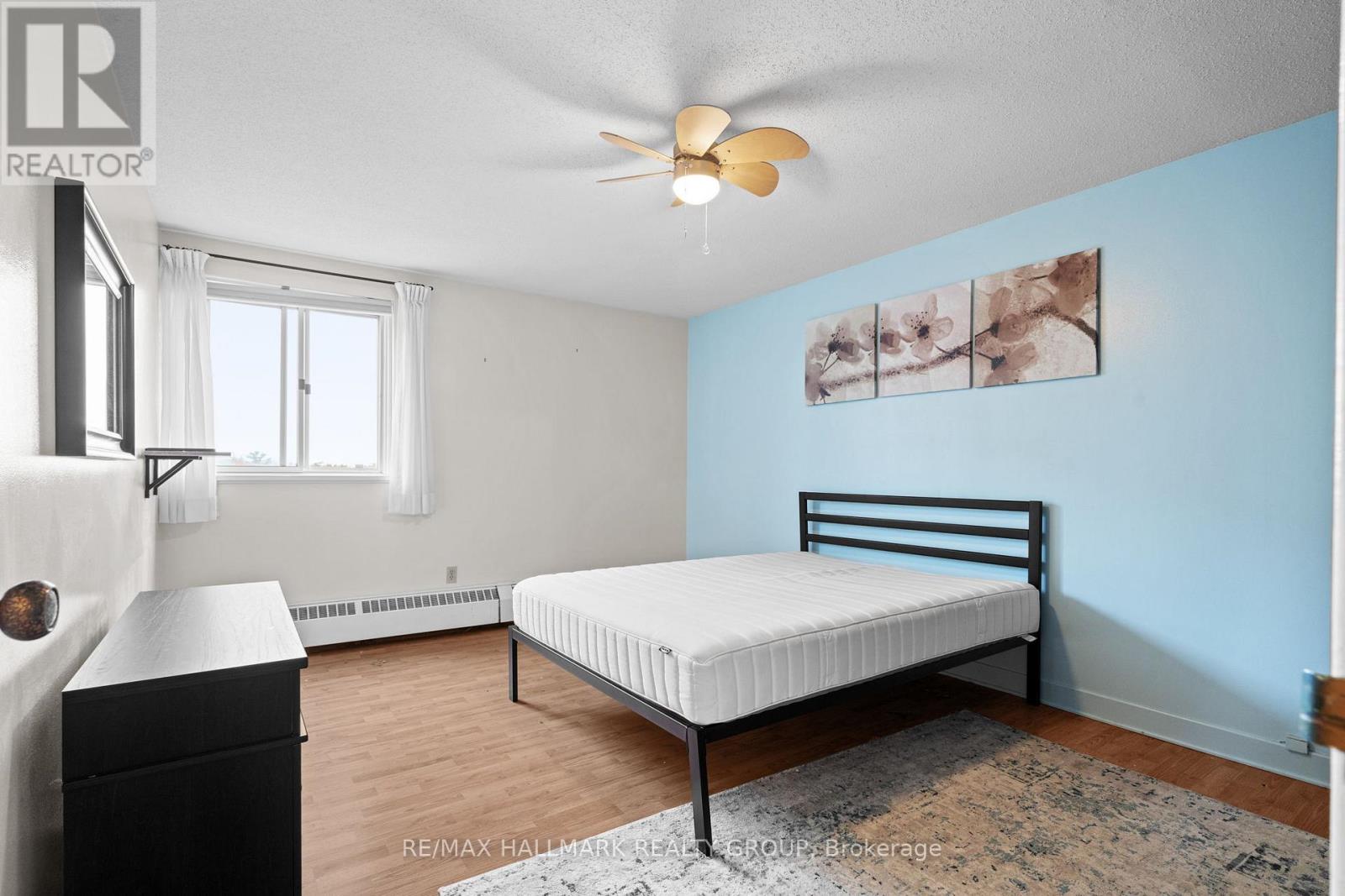 A bedroom with a bed, dresser, and window.