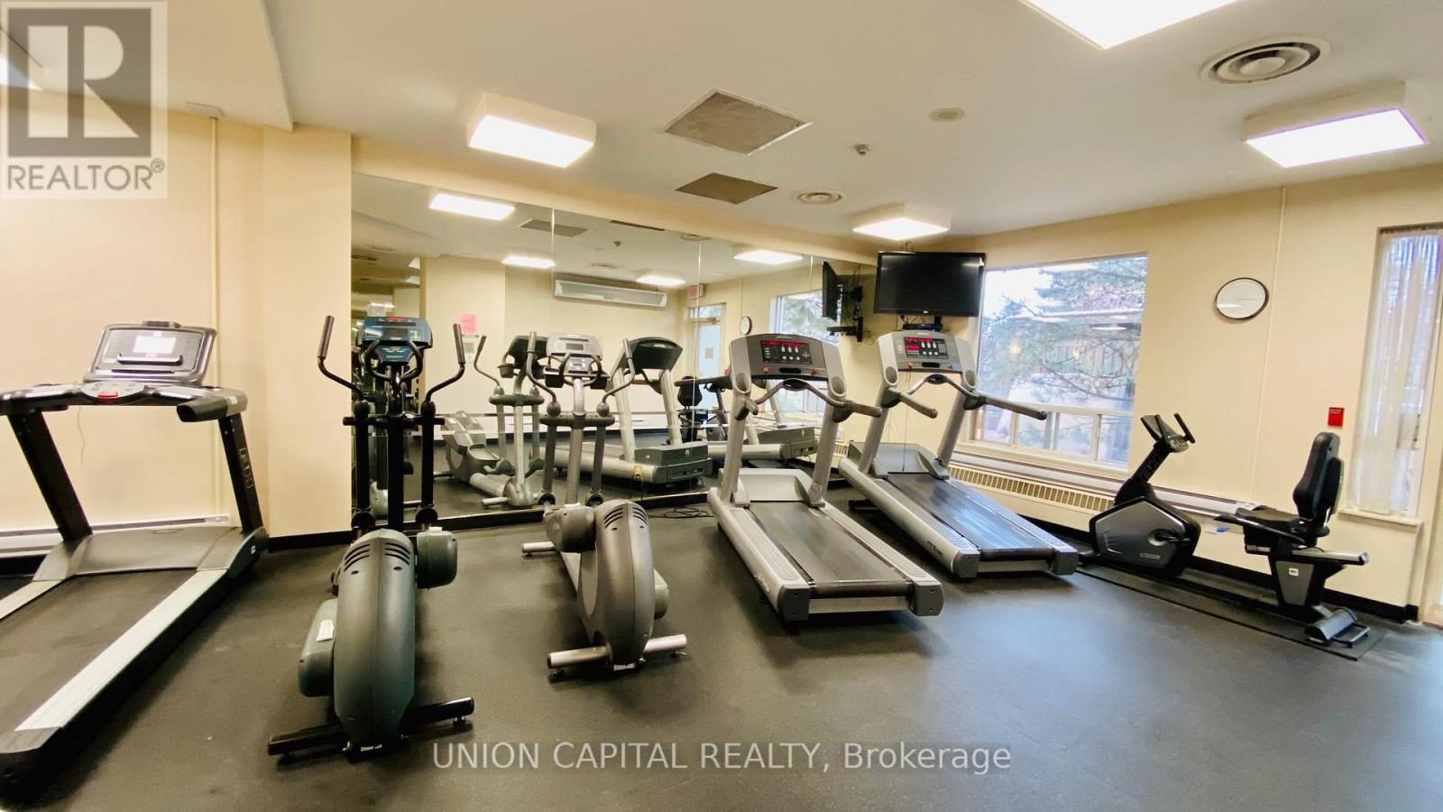 A gym with treadmills, elliptical machines, and other exercise equipment.