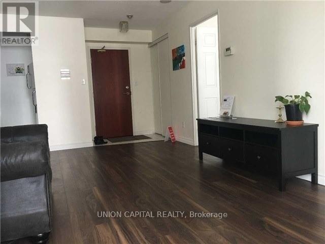 A room with a black desk and a chair in it.