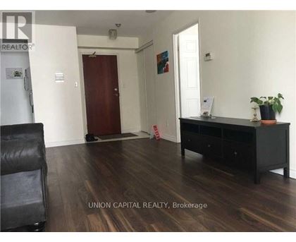 A room with a black desk and a chair in it.