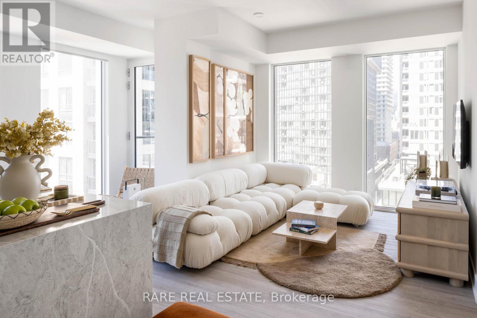 A living room with a large white sofa and a coffee table.