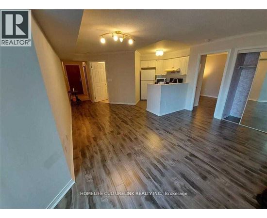 A room with wooden flooring and a white kitchen island.
