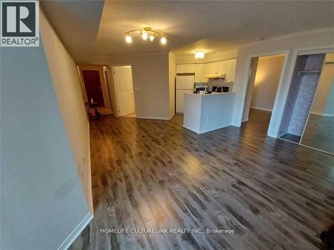 A room with wooden flooring and a white kitchen island.