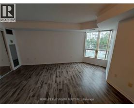 A room with wooden flooring and a large window.