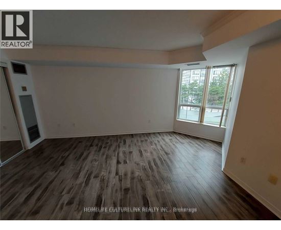 A room with wooden flooring and a large window.