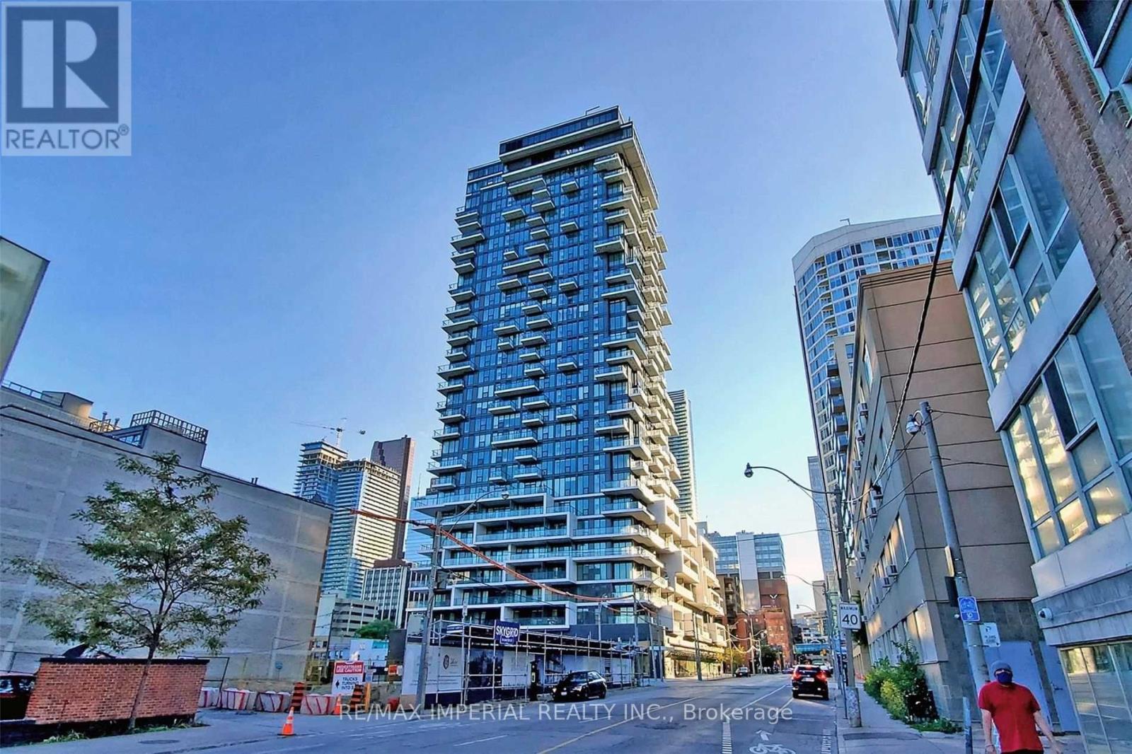 A tall building with many windows is under construction in a city.