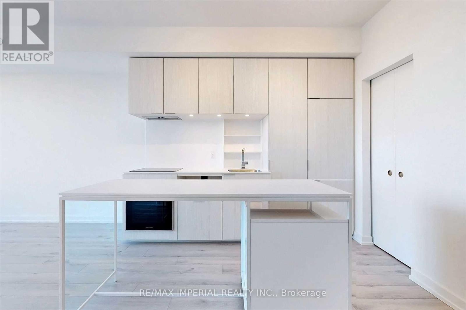 A modern kitchen with white cabinets and a central island.
