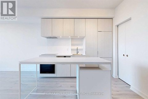 A modern kitchen with white cabinets and a central island.