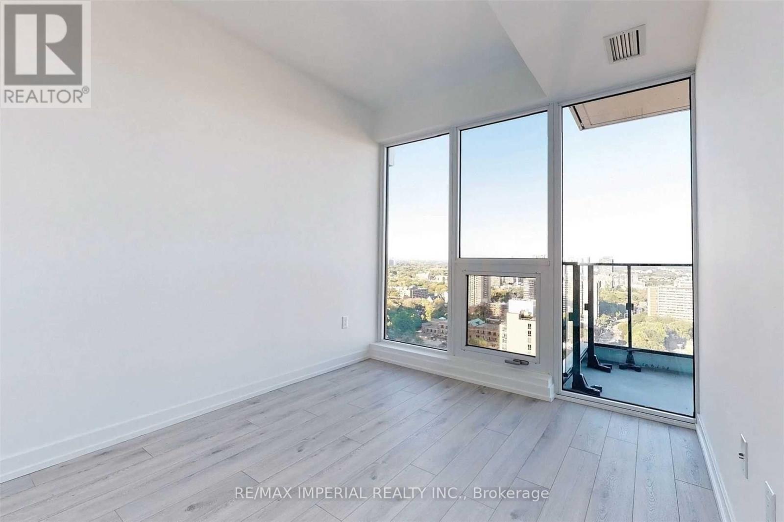 A spacious room with a view of the city through large windows.