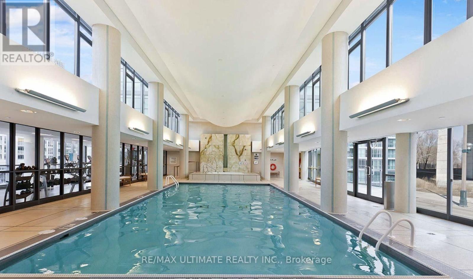 A large indoor swimming pool with a tiled floor and walls.