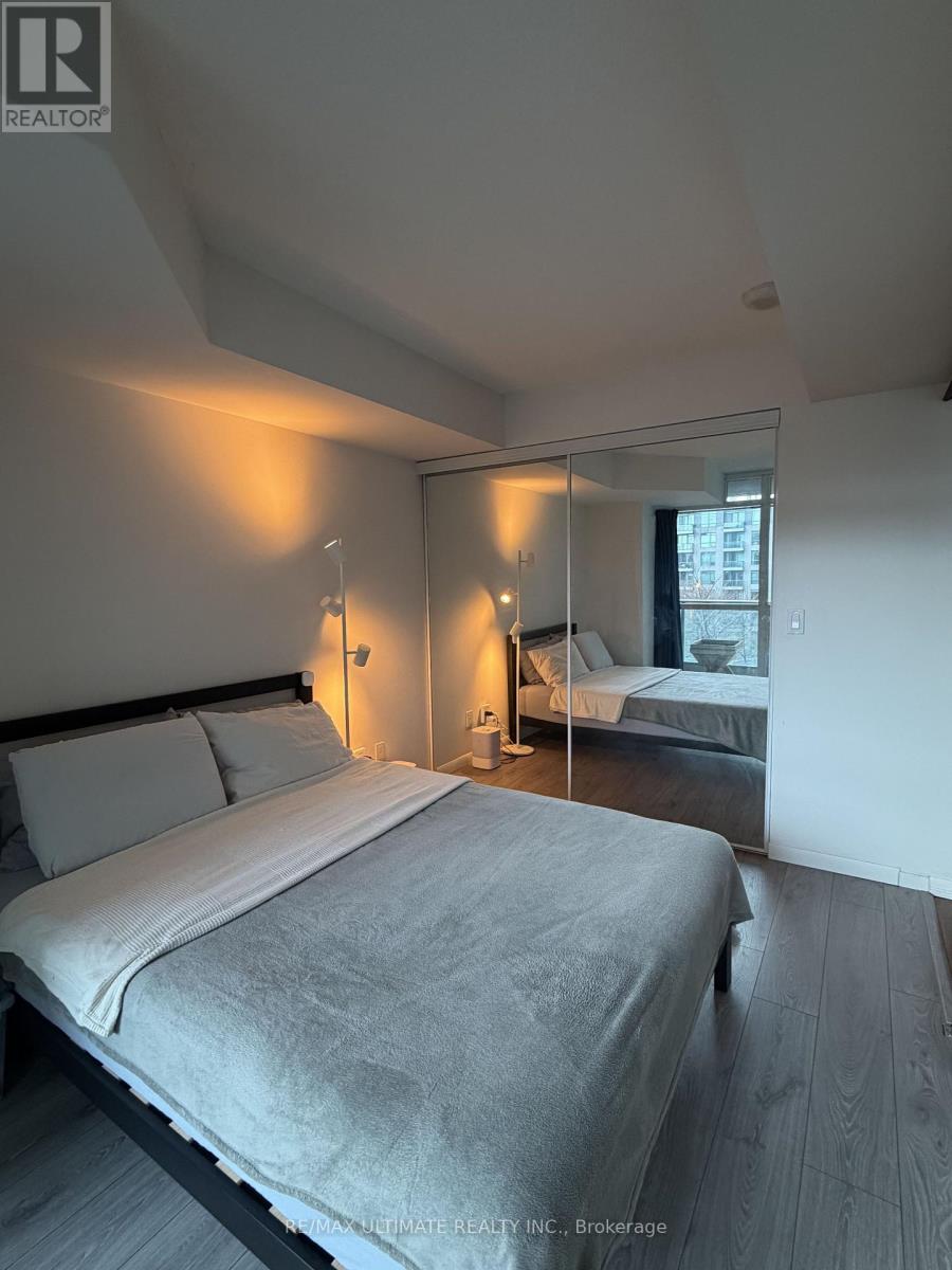 A bedroom with a bed, nightstand, and lamp.
