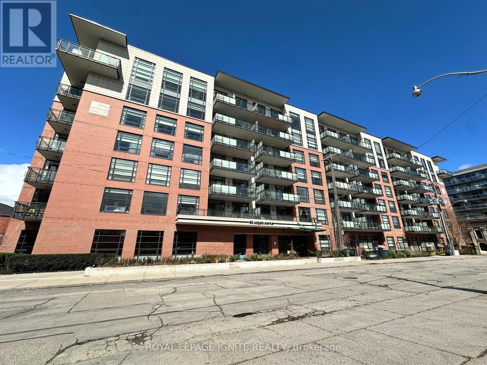 A large apartment complex with multiple balconies and a clear blue sky above.