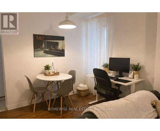 A home office with a desk, chair, and a poster on the wall.