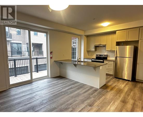 A kitchen with a refrigerator, stove, and oven.