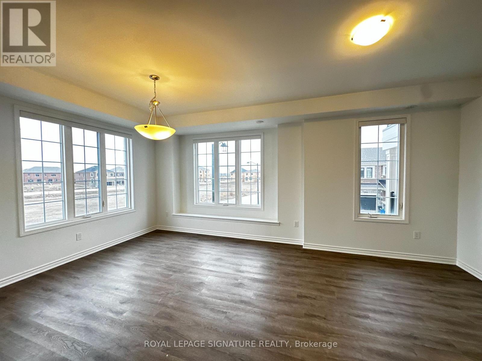 A large empty room with wooden floors and white walls.