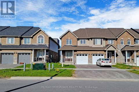A row of houses with a car parked in front of the first house.
