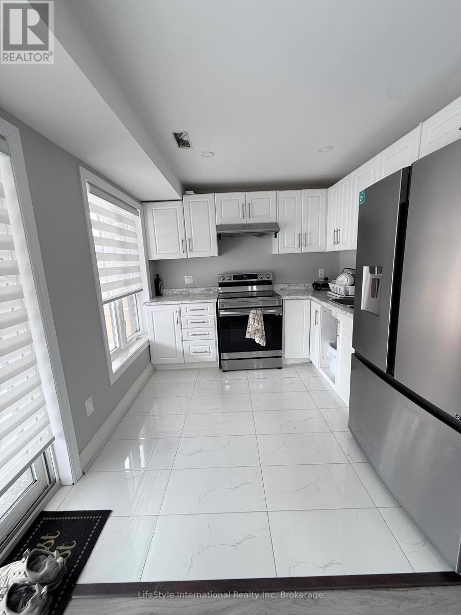 A modern kitchen with white cabinets and a black refrigerator.