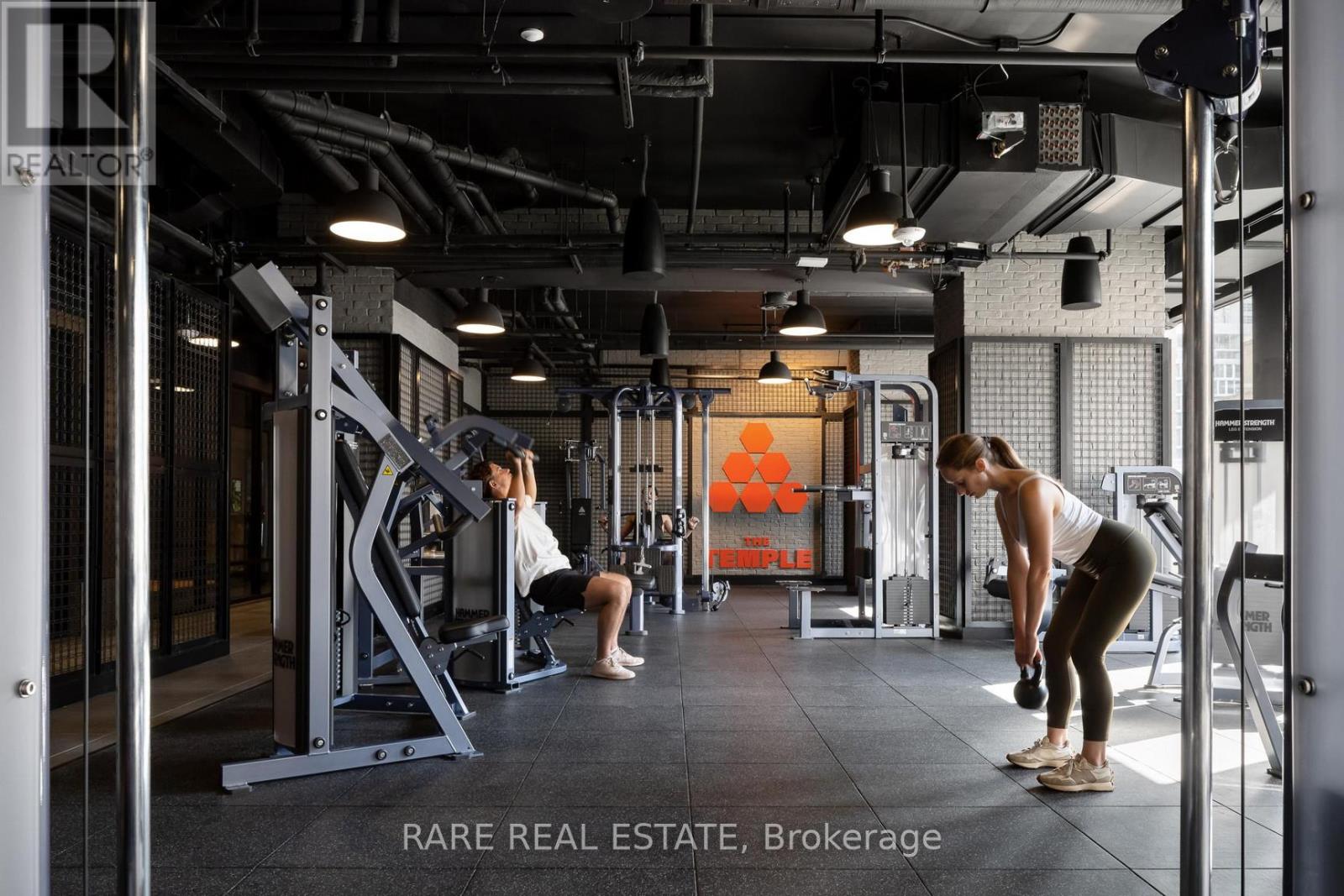 A gym with a woman doing squats and a man doing bicep curls.