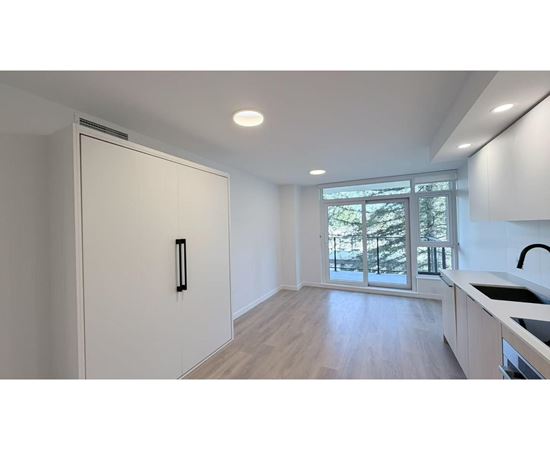 A kitchen with a white fridge and wooden floors.
