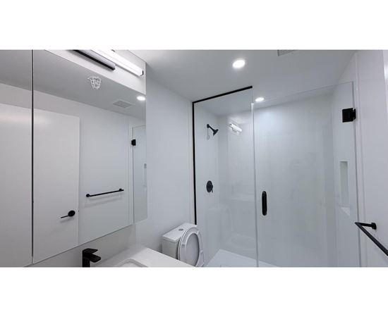 A white bathroom with a toilet, sink, and shower.
