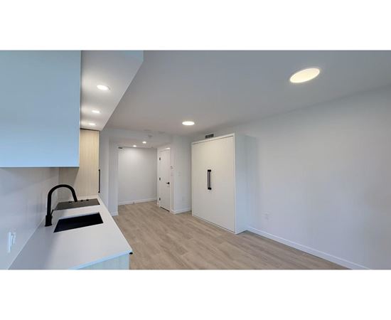 A kitchen with a white counter and a sink.