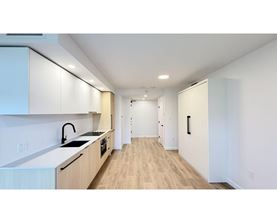 A modern kitchen with wooden floors and white walls.