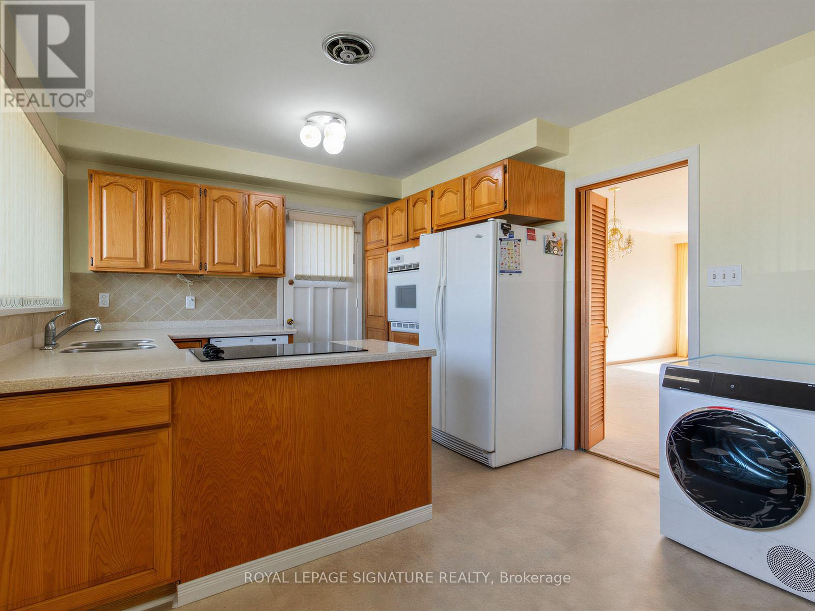 A kitchen with wooden cabinets and a white refrigerator.