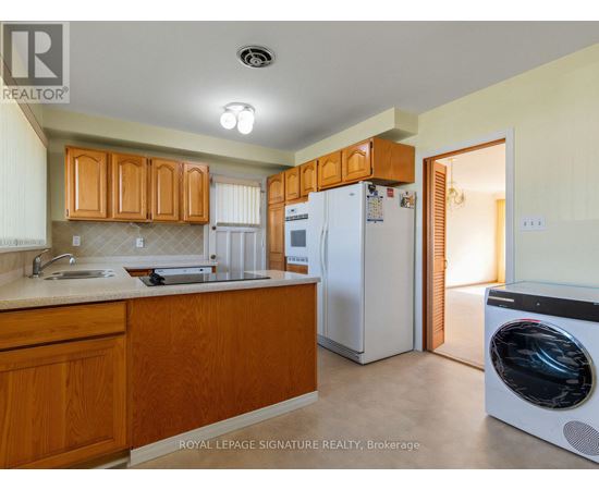 A kitchen with wooden cabinets and a white refrigerator.