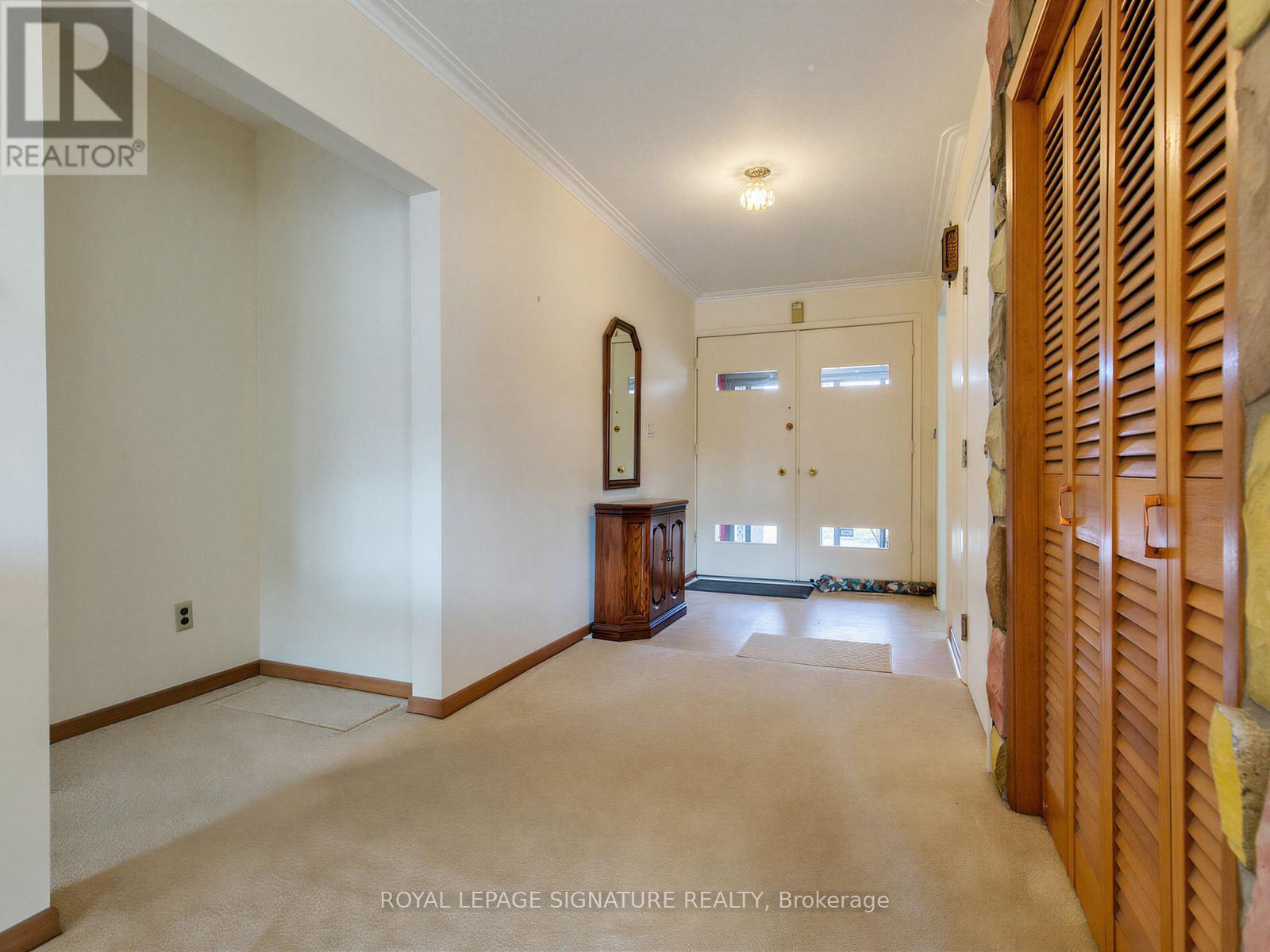 A spacious room with a large mirror and wooden furniture.