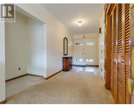 A spacious room with a large mirror and wooden furniture.