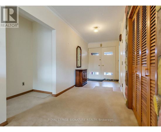 A spacious room with a large mirror and wooden furniture.