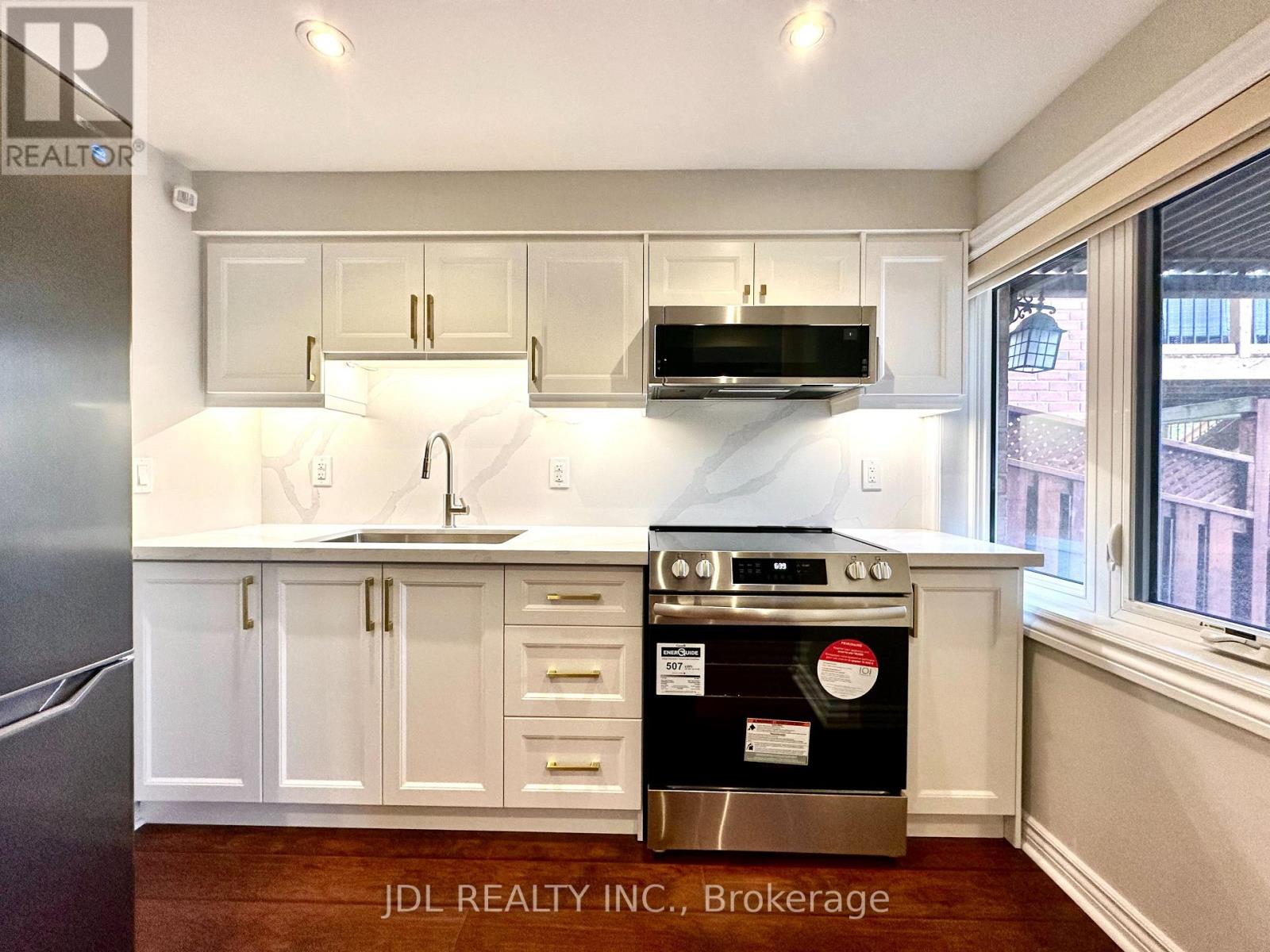 A kitchen with white cabinets and a stainless steel oven.