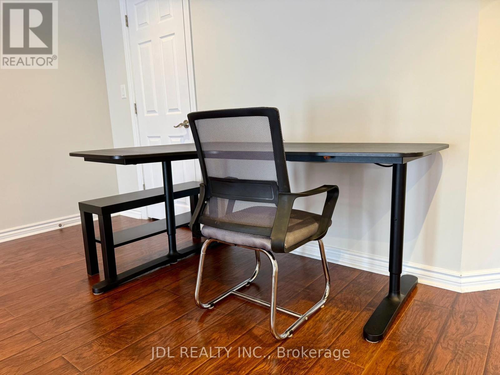 A black chair and table with a black base is in a room.