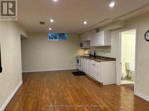 A kitchen with white cabinets and a wooden floor.